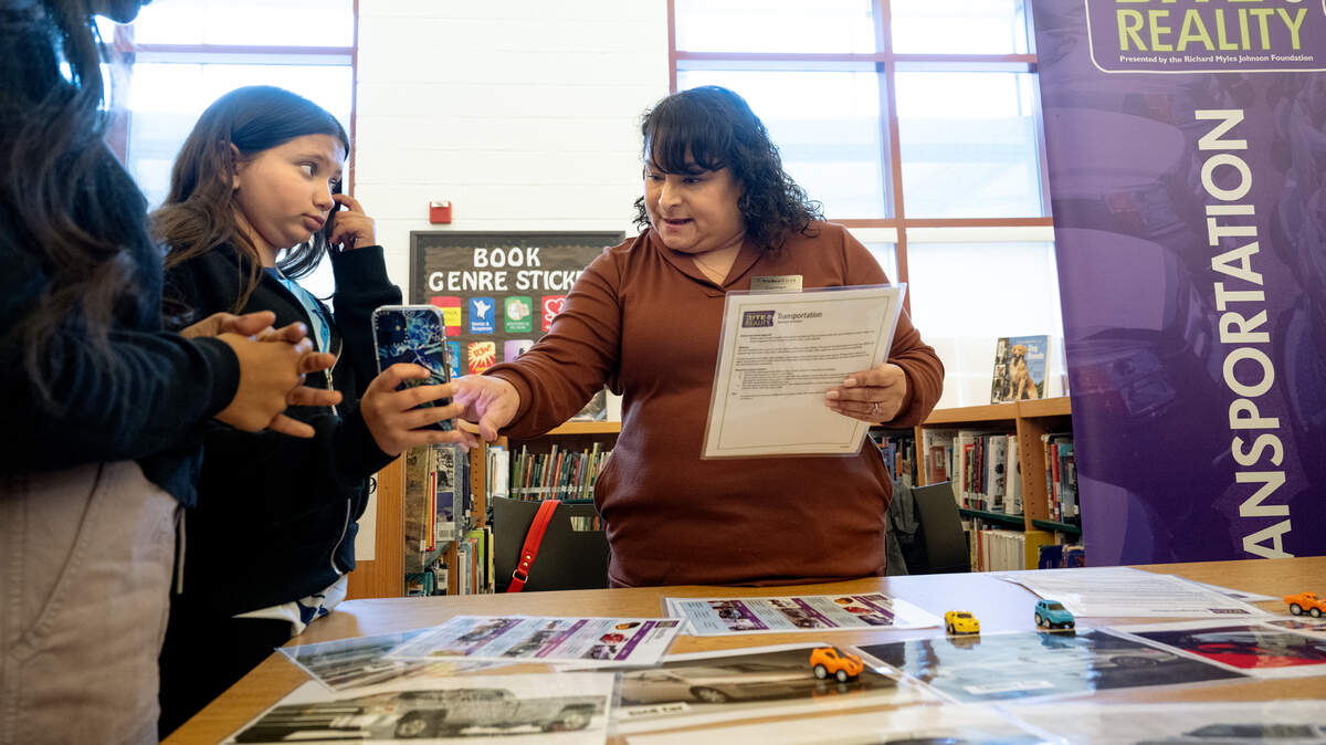 Carmen Artiga from Valley First Credit Union, right, helps eighth-grade student Zoya Hafiv, left, purchase a car during an after school financial literacy event at Glick Middle School in Empire, Wednesday, Dec. 11, 2024. Students were given a career and monthly salary and went to different stations to purchase goods as part of a simulation that has students make real world financial decisions.