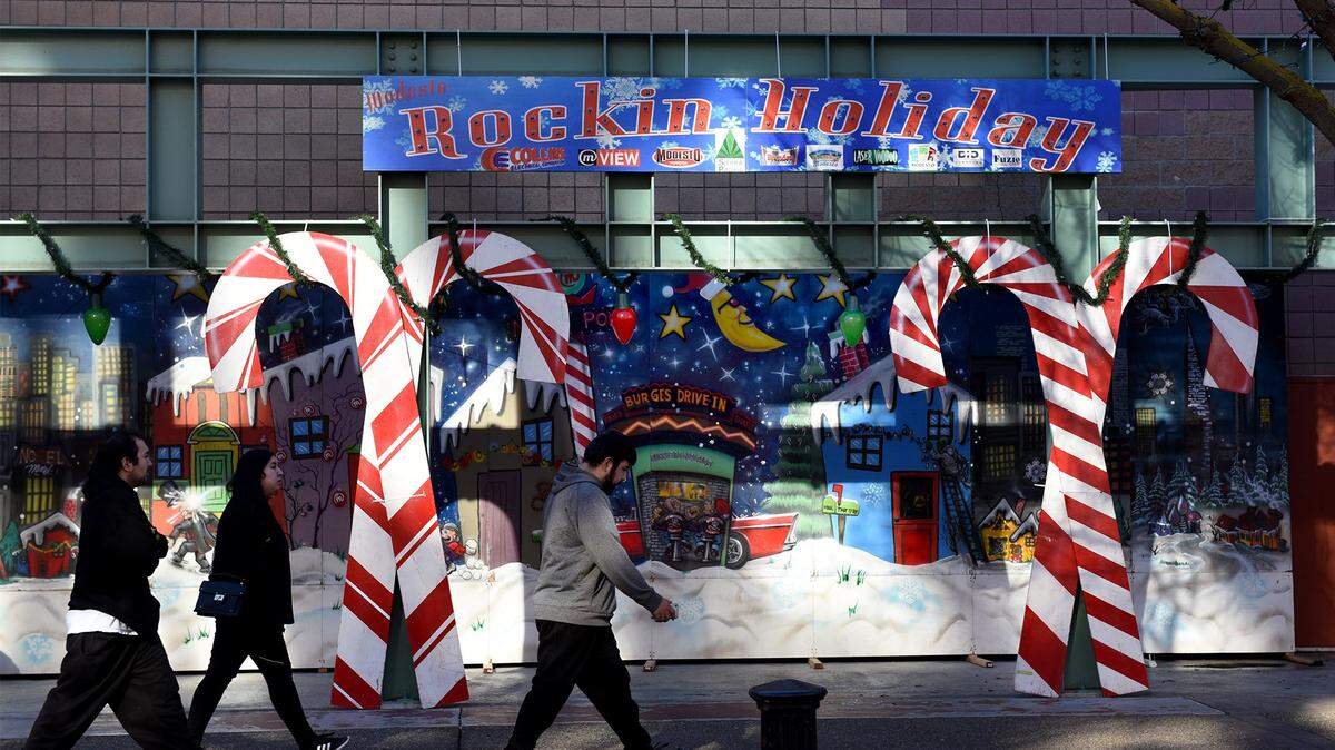People pass by part of a past year’s Rockin’ Holiday Christmas display.