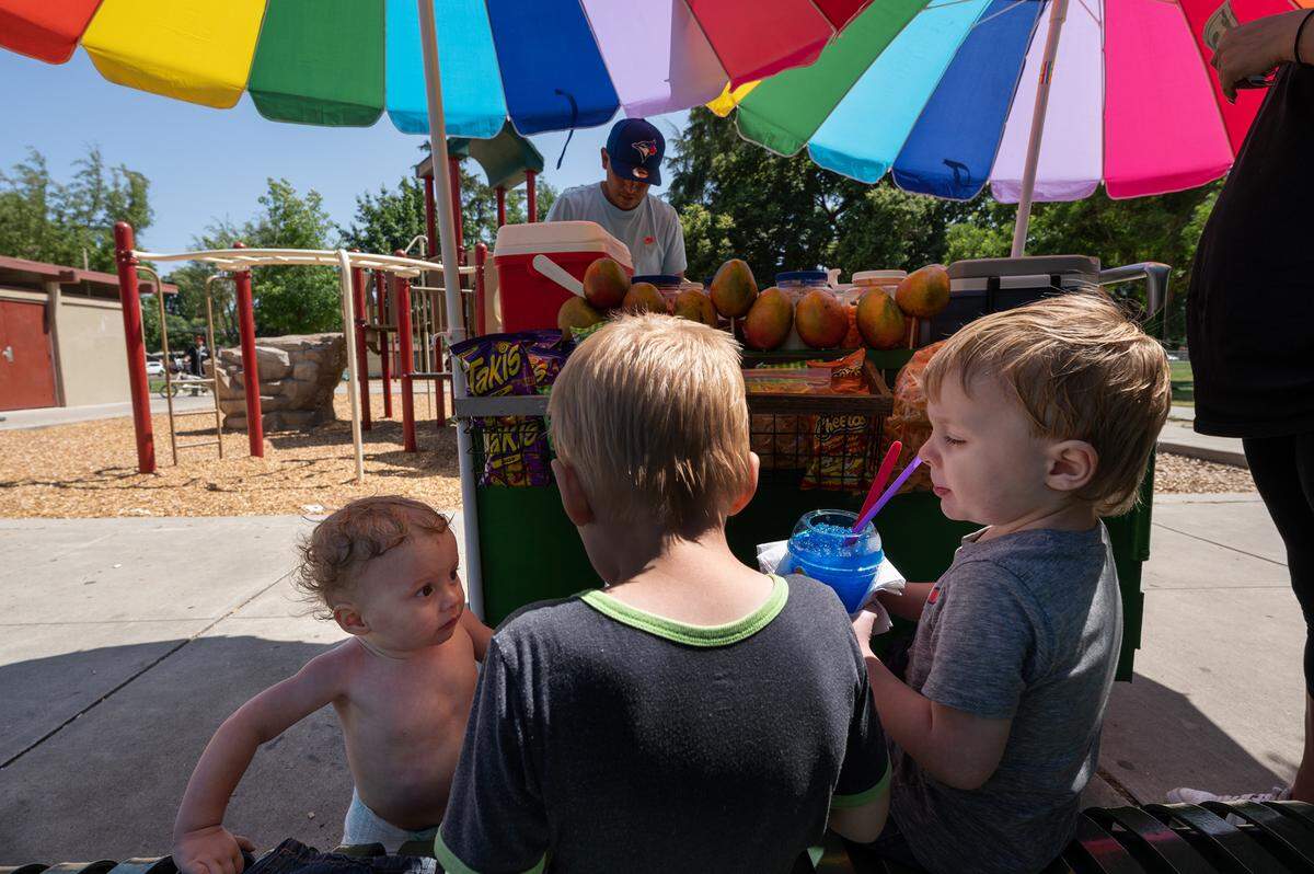 Brothers Dakota, 5, Bentley, 3, right and Ezekiel, 1, take a break from playing in the water feature at Marshall Park in Modesto, Calif., Thursday, June 1, 2023.