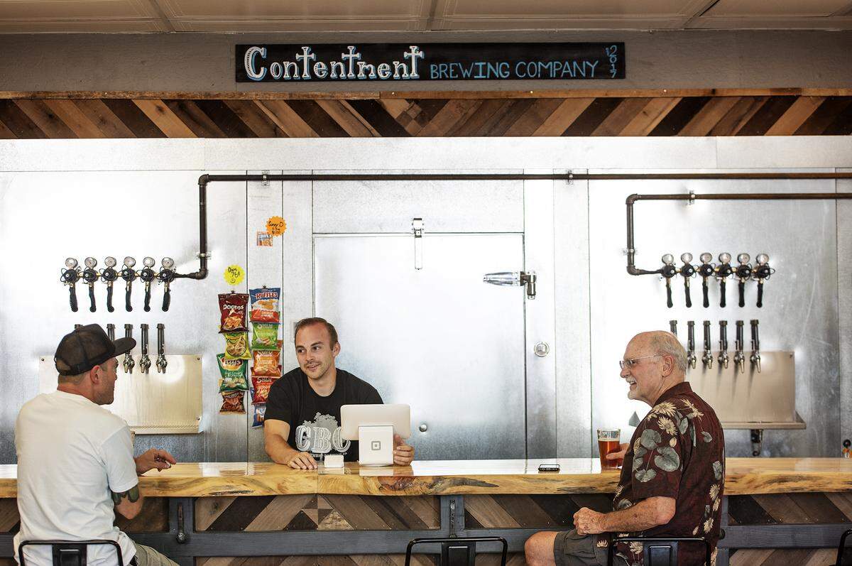 Bartender Andrew Molica, middle, talks with John Bryon, right, and another guest at Contentment Brewing Company in Modesto, Calif., Friday, July 19, 2019.