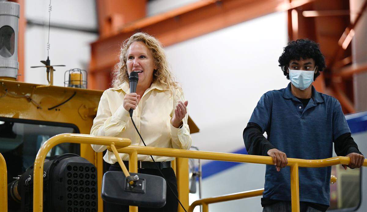 Christina Fugazi, chair of the San Joaquin Regional Rail Commission board, speaks to guests, with Edison High senior Christian Sharma, right, during an open house to announce the creation of the Rail Academy of Central California in Stockton, Calif., on Wednesday, May 25, 2022. The program will launch in August, with classroom training at a community college and hands-on work at the ACE maintenance facility.