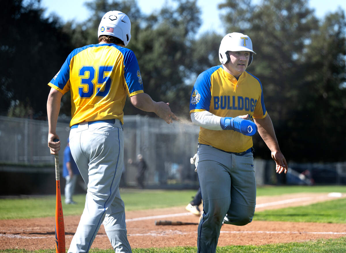 Turlock’s Owen Miller scores as teammate Tyler Castro (35) walks to the plate during the March Madness baseball tournament game with Central Catholic in Modesto, Calif., Friday, March 8, 2024.