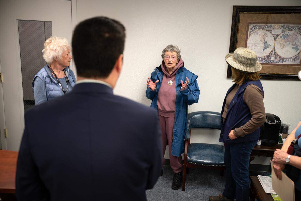 Diane Kroeze, middle, speaks to Matt Reed, district chief of staff for Congressmember Tom McClintock, at the district office in Modesto on Monday, Feb. 24, 2025.