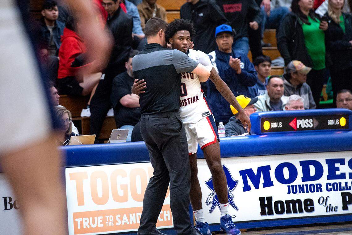Modesto Christian coach Brice Fantazia hugs senior Jalen Brown as he leaves the game in the final minute of the NorCal Open Division championship game with St. Joseph at Modesto Junior College in Modesto, Calif., Tuesday, March 7, 2023. St. Joseph won the game 72-58.