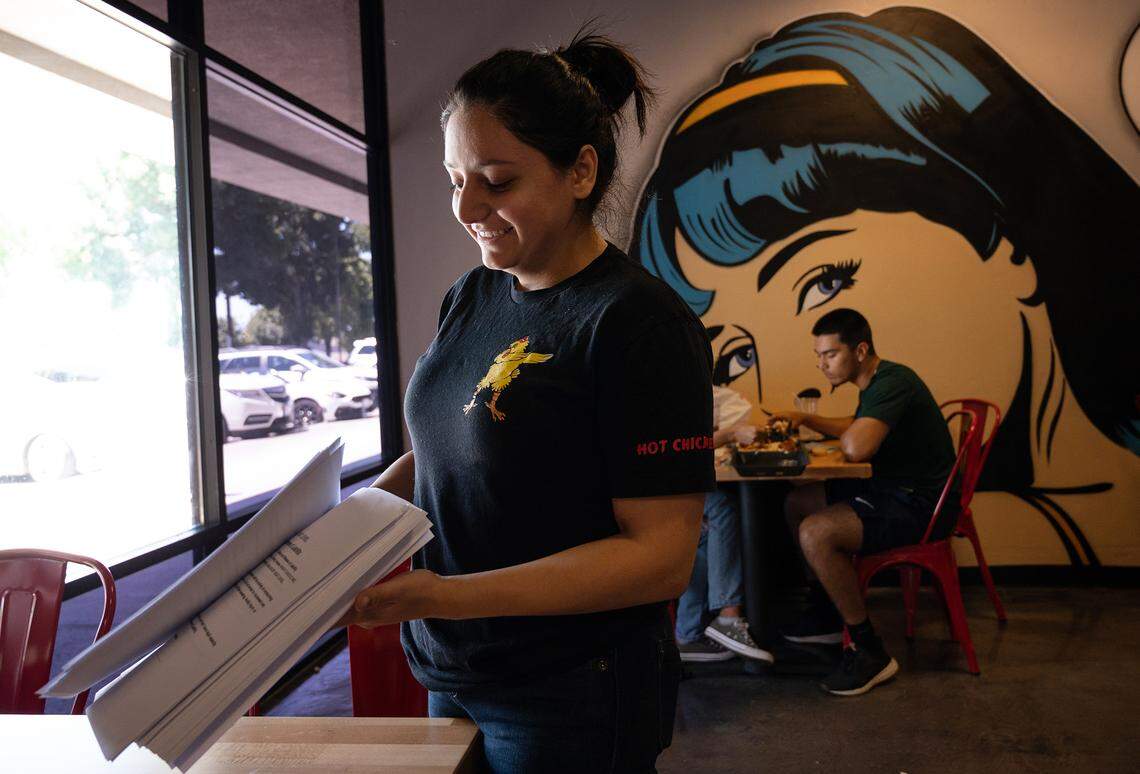 Mary Mkhitaryan holds a stack of signed waivers at Angry Chickz restaurant in Ceres, Calif., on Thursday, July 15, 2021. Chicken made with the certified world’s hottest pepper, the Carolina Reaper, requires that customers sign a waiver before eating.