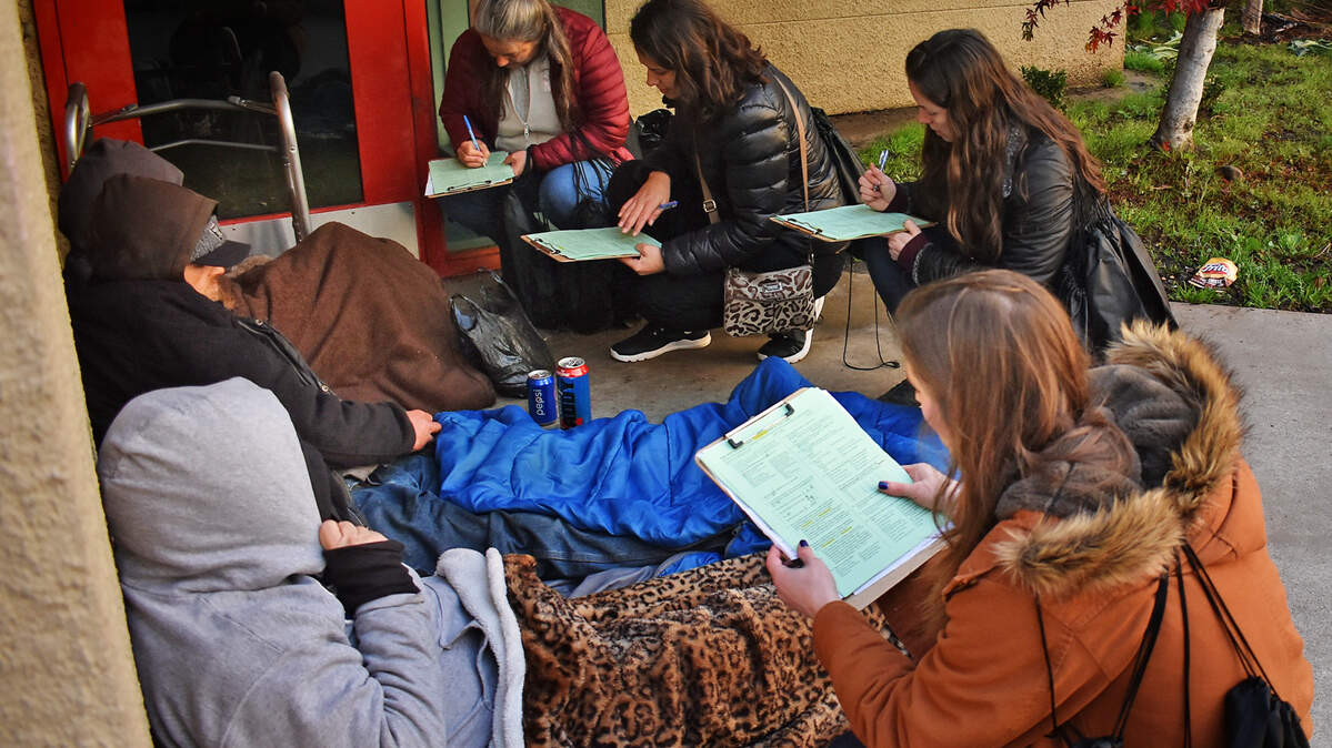 Homeless people sitting outside the Salvation Army Child Development Center in downtown Modesto are interviewed for the Stanislaus County point-in-time count Thursday morning, Jan. 23, 2020.