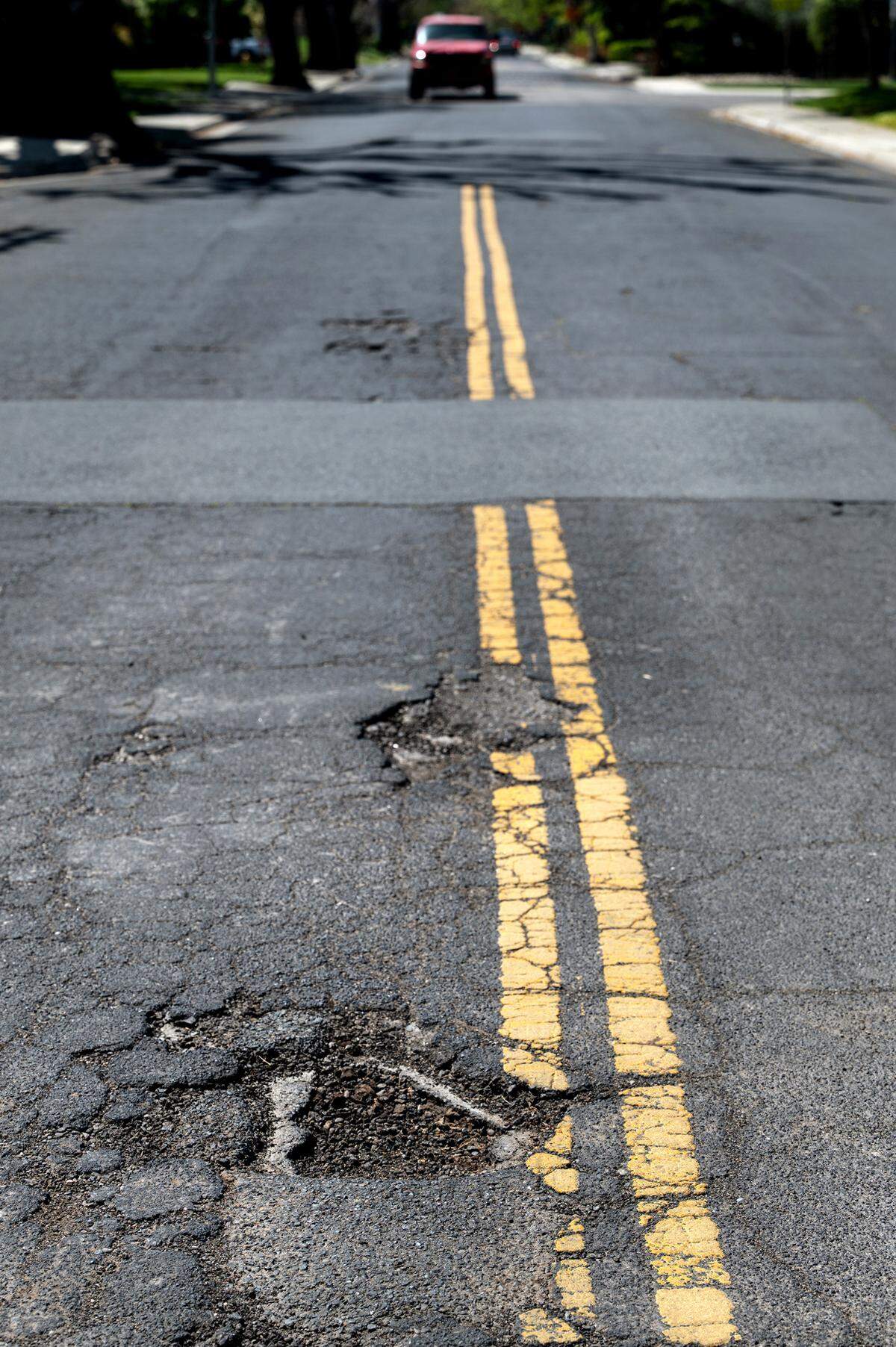 Potholes on Griswold Avenue in Modesto, Calif., Thursday, April 13, 2023.