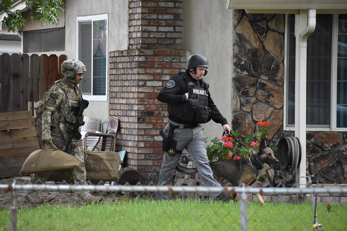 Modesto police assisted the FBI in serving a search warrant at a home on Mission Bell Lane in east Modesto on Wednesday morning, April 11, 2018. Here, officers walk through a neighboring yard at Lakehead and Bateman lanes.