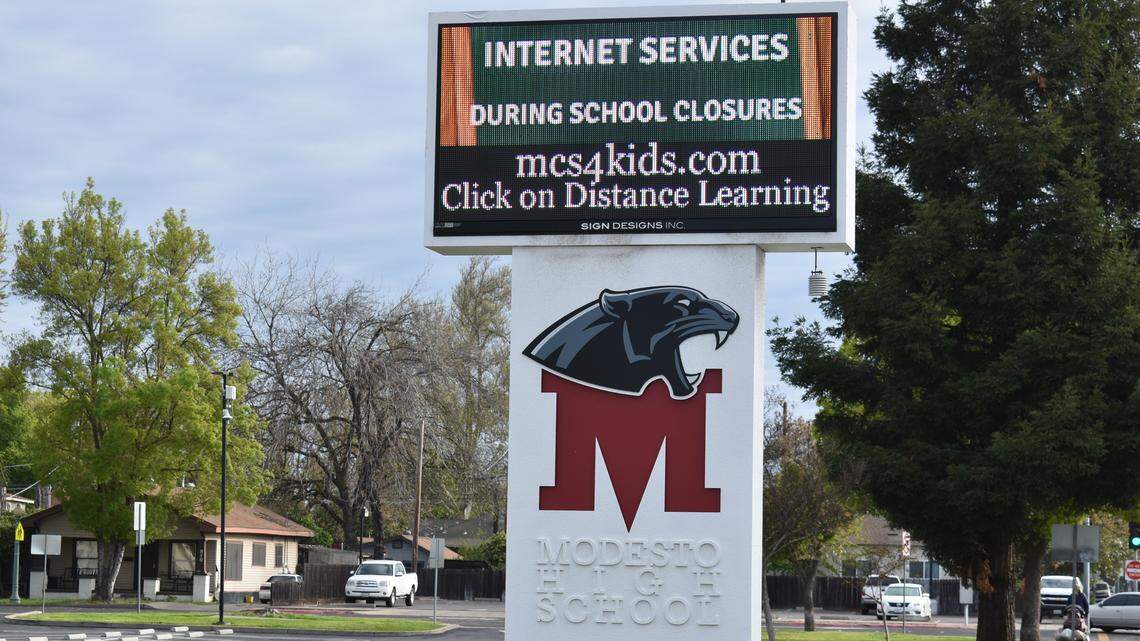 The Modesto High School parking lots are empty Tuesday, March 31, 2020, as the school sign shows messages about where to get information on distance learning, meal pickup and other coronavirus closure topics.