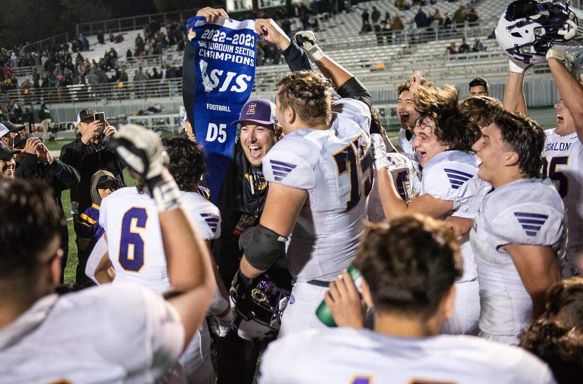 Escalon’s head coach Andrew Beam holds the section title banner as he and his team celebrate their 35-34 victory over Sonora in the Sac-Joaquin Section Division V championship game at St. Mary’s High School in Stockton, Calif., Saturday, Nov. 26, 2022.