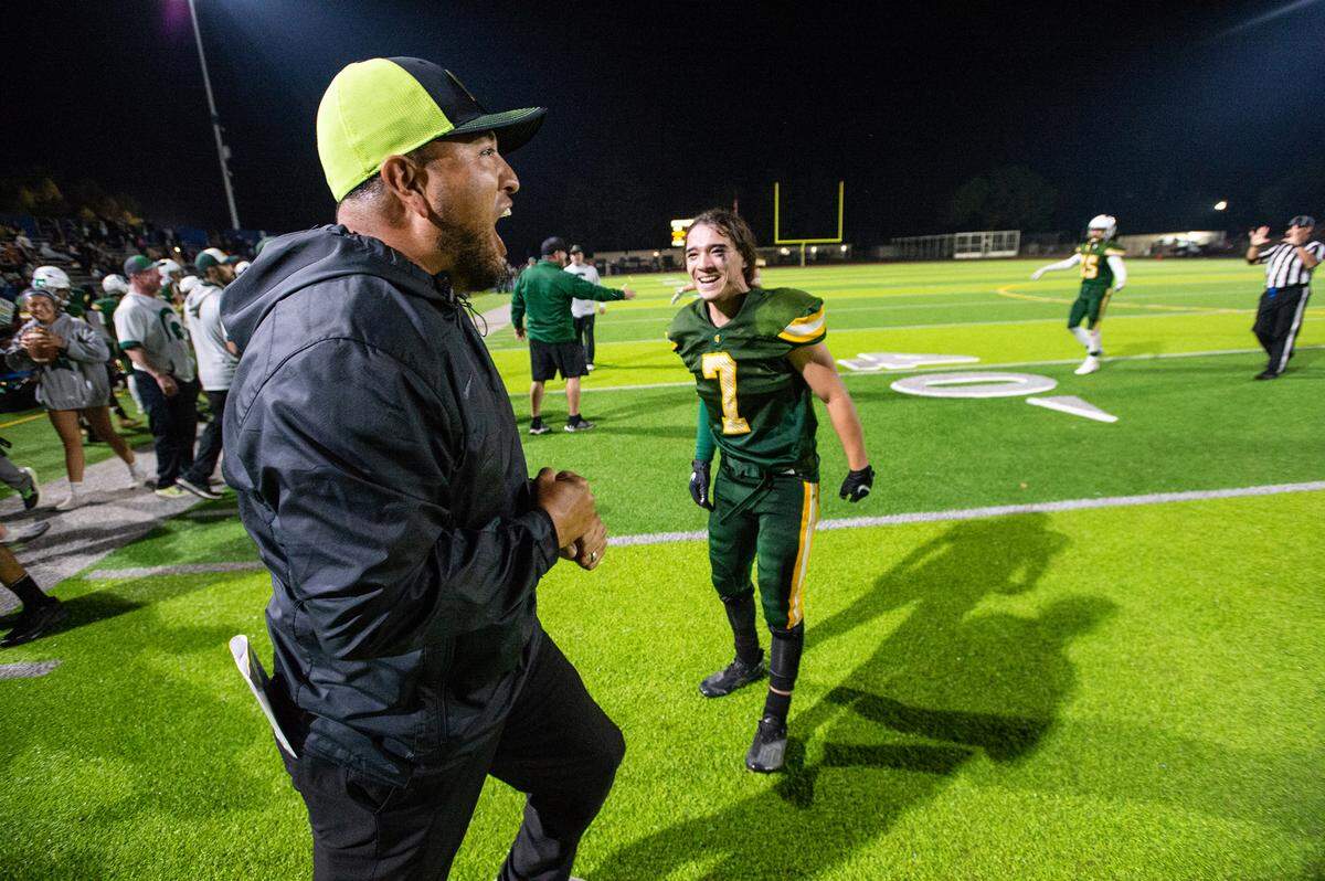 Davis coach Tim Garcia, left, and player Jordan Mendoza (7) celebrate their 33-24 victory over Ceres in the Western Athletic Conference game at Downey High School in Modesto, Calif., on Thursday, Oct. 28, 2021.