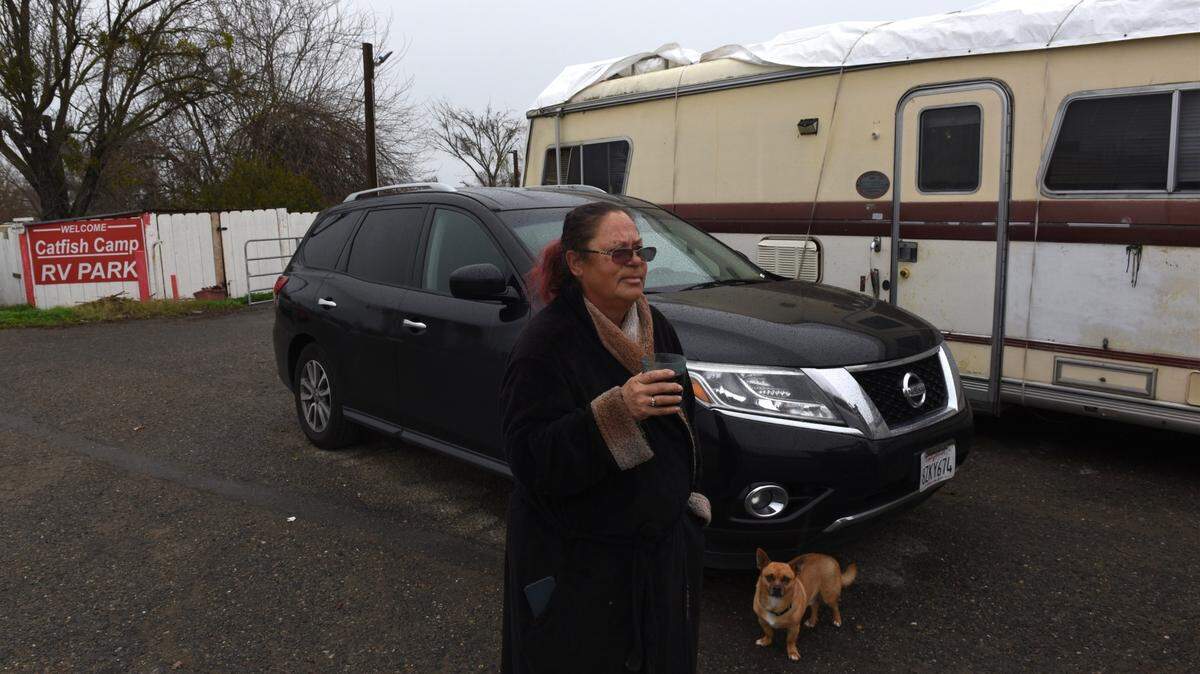 Resident Danita Corley, with her dog, Moochie, prepares to leave the Catfish Camp mobile home park along the San Joaquin River at Crows Landing Road on Wednesday, Jan. 11, 2023. She said that sheriff’s deputies told her it is a mandatory evacuation and that most people moved their trailers up to high ground along Crows Landing Road.