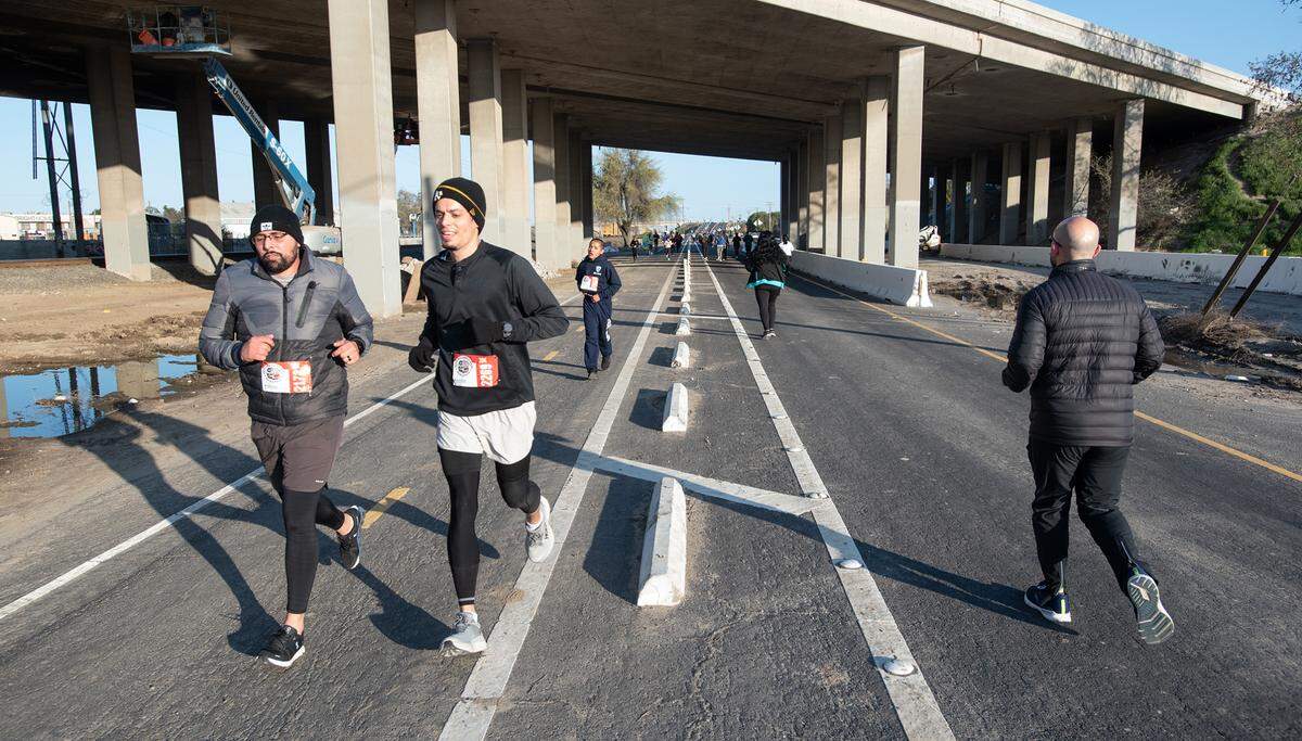 Runners head out and return on 9th Street during the Modesto Marathon in Modesto, Calif., Sunday, March 26, 2023.