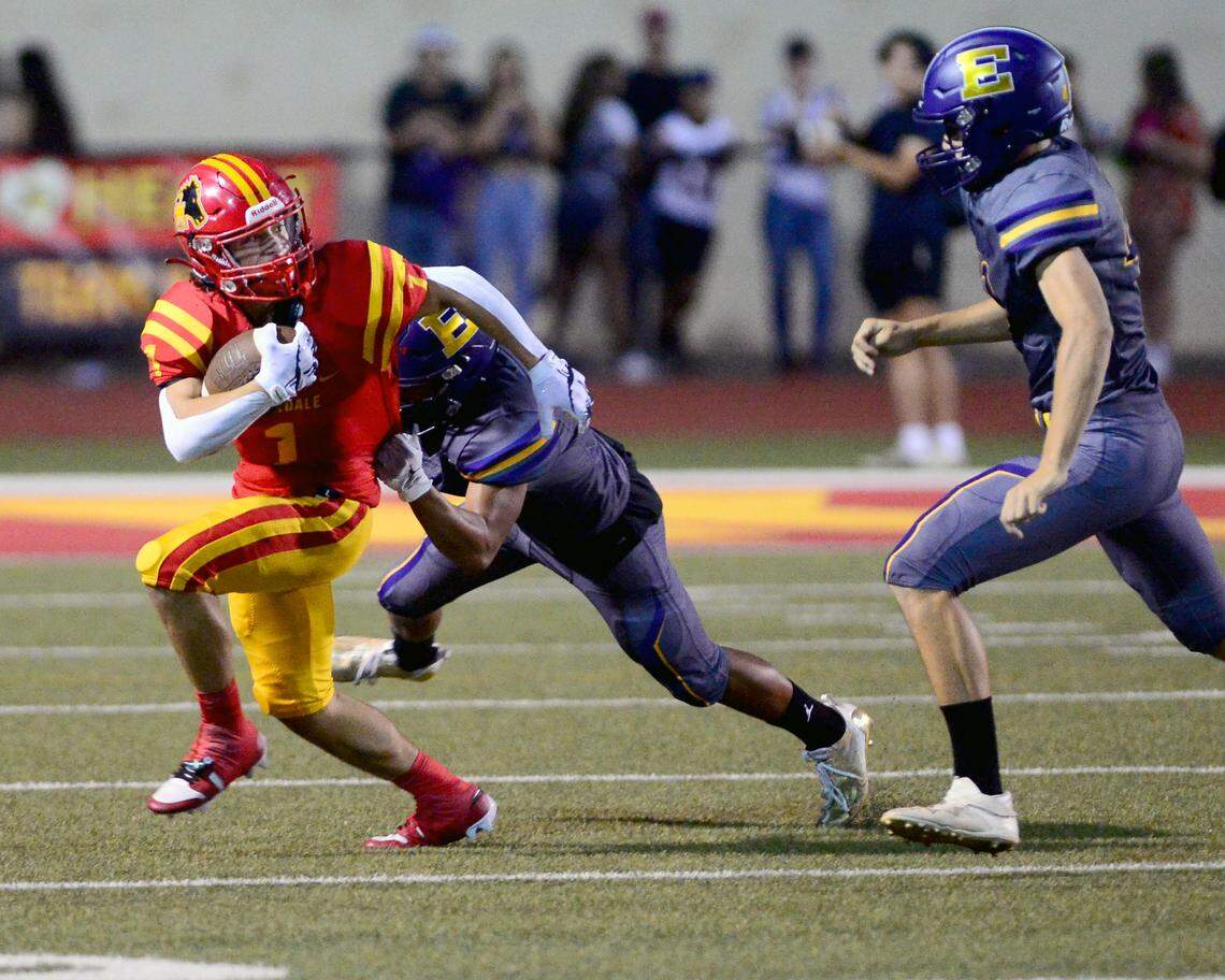 Oakdale running back Gabe McDonald (1) tries to escape two Escalon defenders during a game between Oakdale and Escalon at Oakdale High School in Oakdale, California, on September 15, 2023.