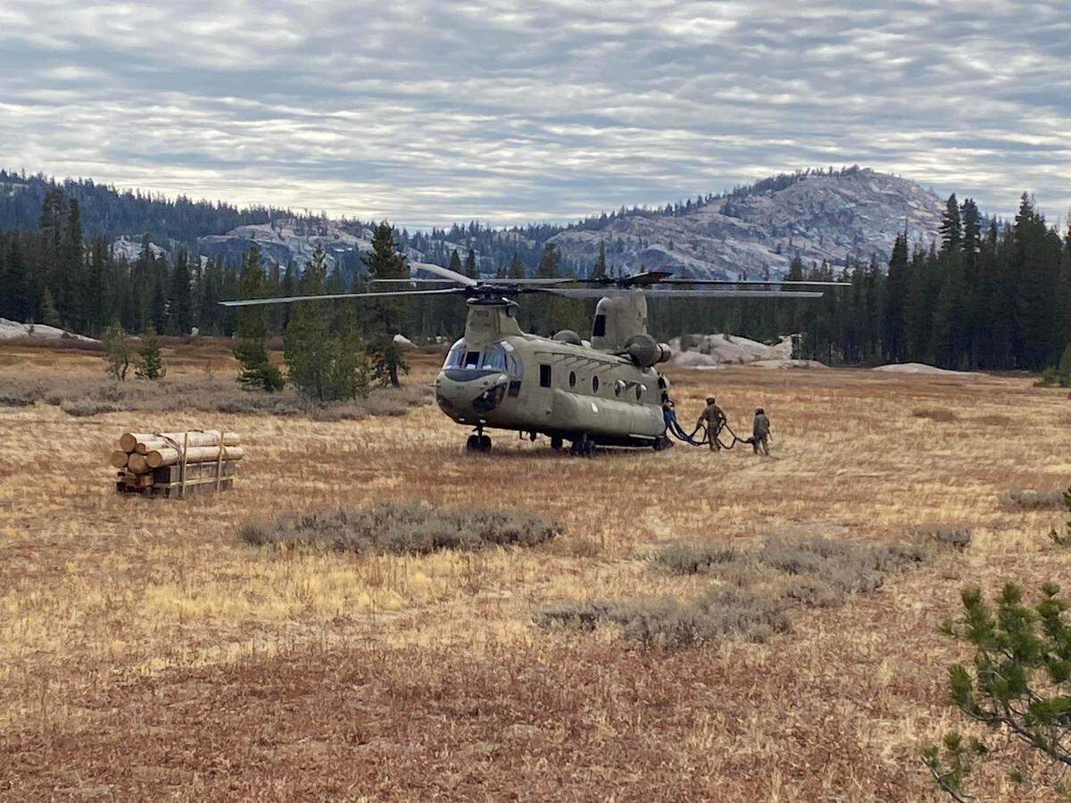 Soldiers with the California National Guard prepare to fly after sling loading timber that will be used to conserve a cultural site, Oct. 30, 2024. Utilizing CH-47 Chinook helicopters from Bravo Company, 1-126th Aviation, Soldiers were able to transport materials that will be used to preserve the cultural site. The location, like many sites in the wilderness was inaccessible by road, in high-altitude, mountainous terrain. (Courtesy photo)