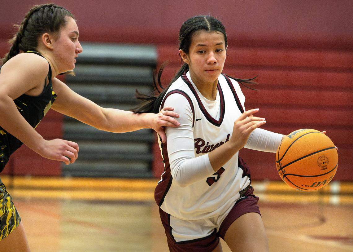 Riverbank’s Leilani Olanolan is defended by Hughson’s Peyton Avila during the non-league game in Riverbank, Tuesday, Dec. 3, 2024.