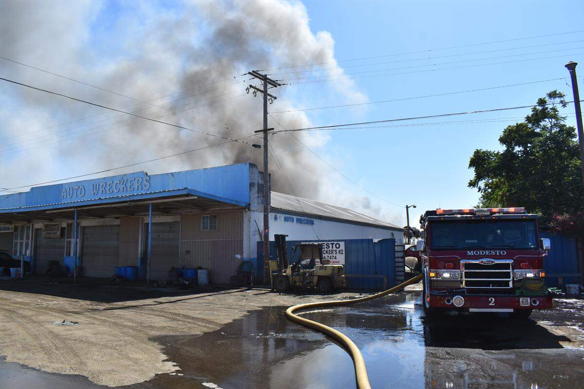 Smoke billows from a fire at an auto salvage yard on Crows Landing Road in south Modesto on Sunday afternoon, May 29, 2022.