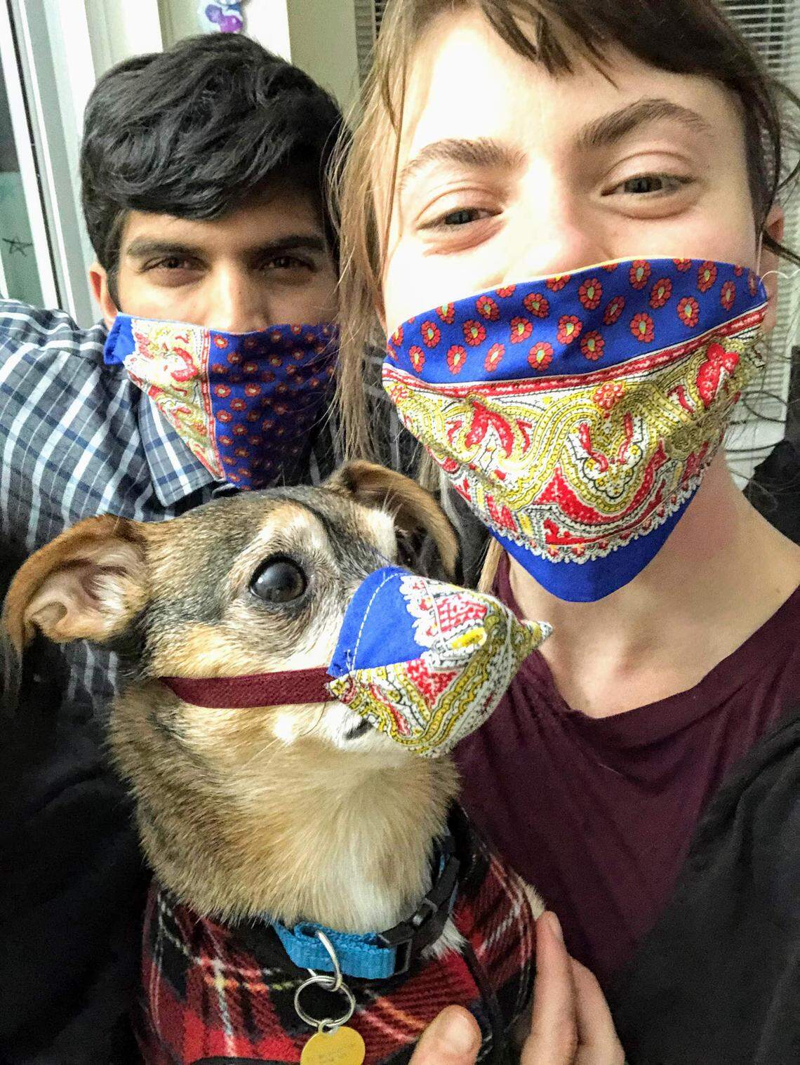 Tyler and Brenly Pereira and their dog, Littlefoot, show off their masks.