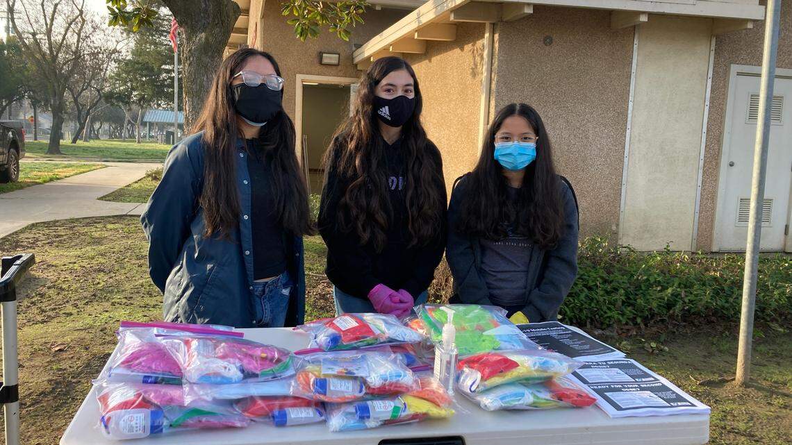 Montseratt Candelario, 15, Mia Alberto, 14, and Cassandra Candelario, 14, youth promotoras or community peer health counselors, volunteer distributing COVID-19 healthy kits at mobile vaccine clinic site at King Kennedy Center in West Modesto on Feb. 8, 2021.