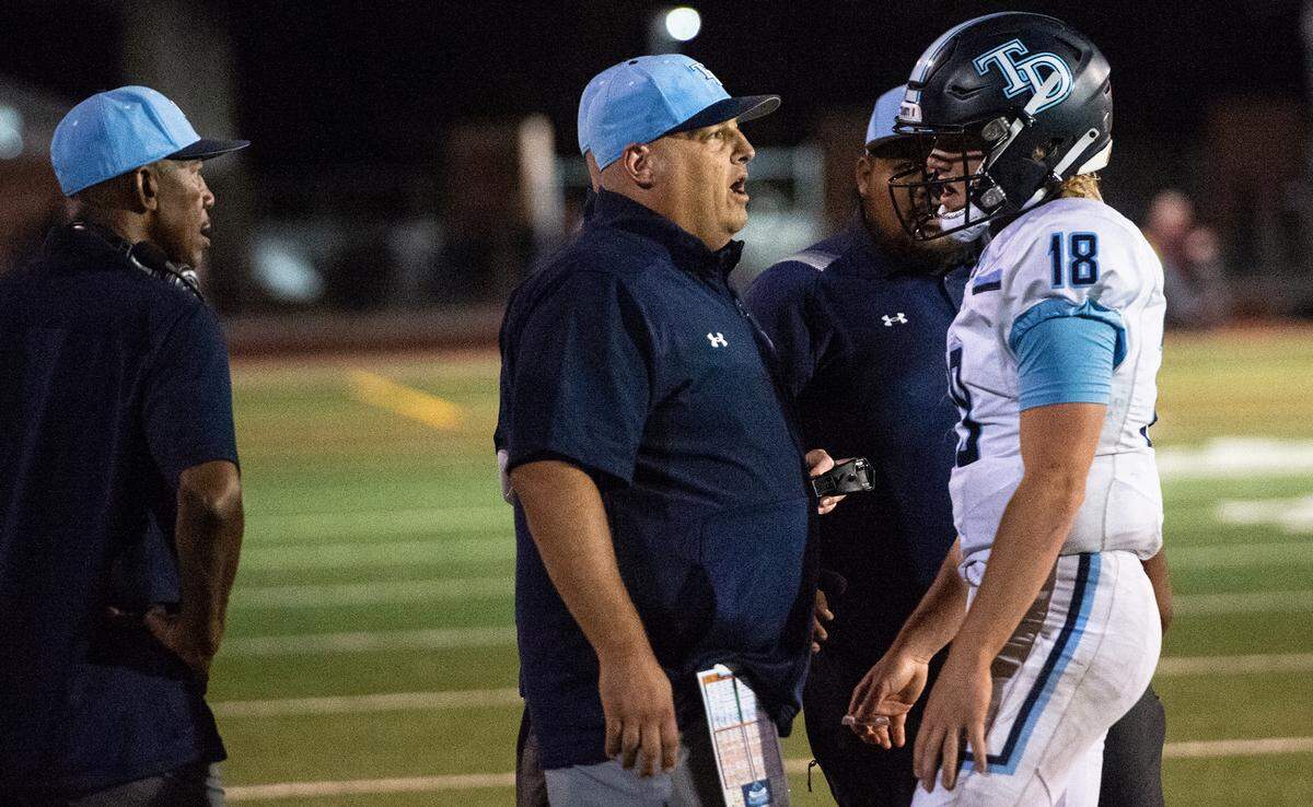Downey quarterback Conner Stoddard talks with head coach Jeremy Plaa late in the fourth quarter during the Central California Athletic League game with Turlock in Turlock, Calif., Friday, Oct. 7, 2022. Downey won the game 24-22.