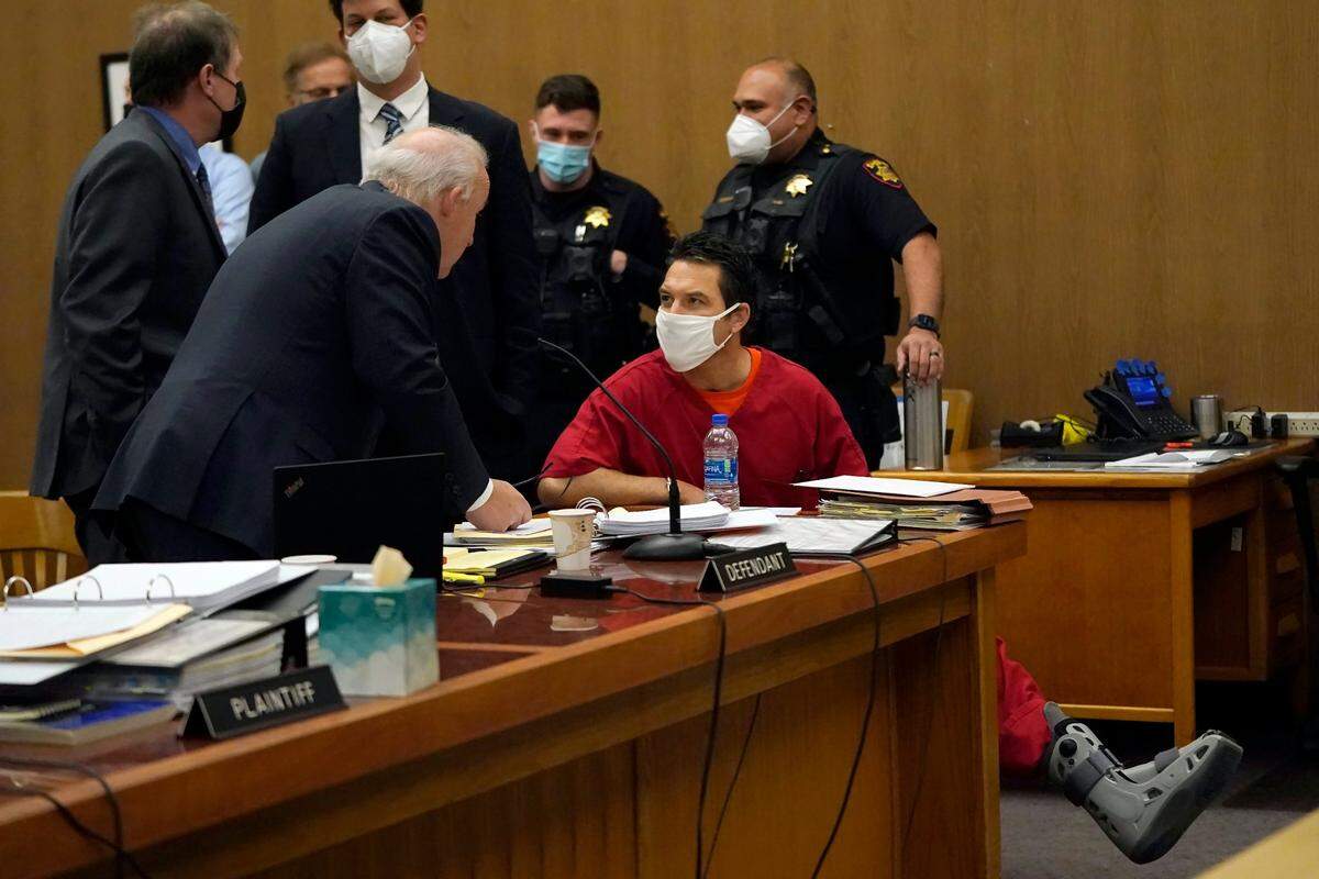 Scott Peterson, seated, speaks to attorney Pat Harris during a break in a hearing at the San Mateo County Superior Court in Redwood City, Calif., Friday, Feb. 25, 2022. Peterson’s chance for a new trial in the murder of his pregnant wife 20 years ago hinges on whether a California juror who helped convict him was biased. (AP Photo/Jeff Chiu, Pool)