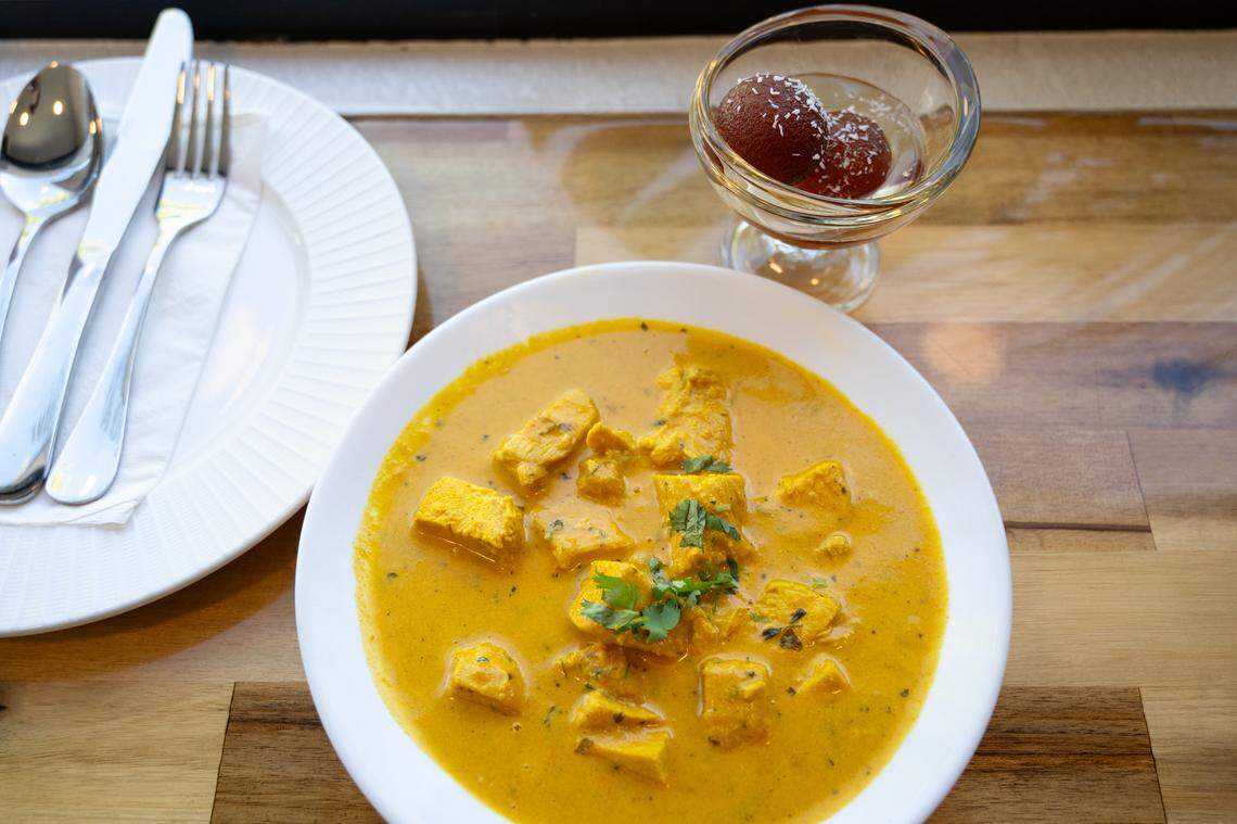 Curry chicken and Gulab Jamun dessert (dumplings made of thickened milk in syrup) at Tandoori Flame restaurant on 10th Street in Modesto, Calif., Wednesday, Sept. 27, 2023.