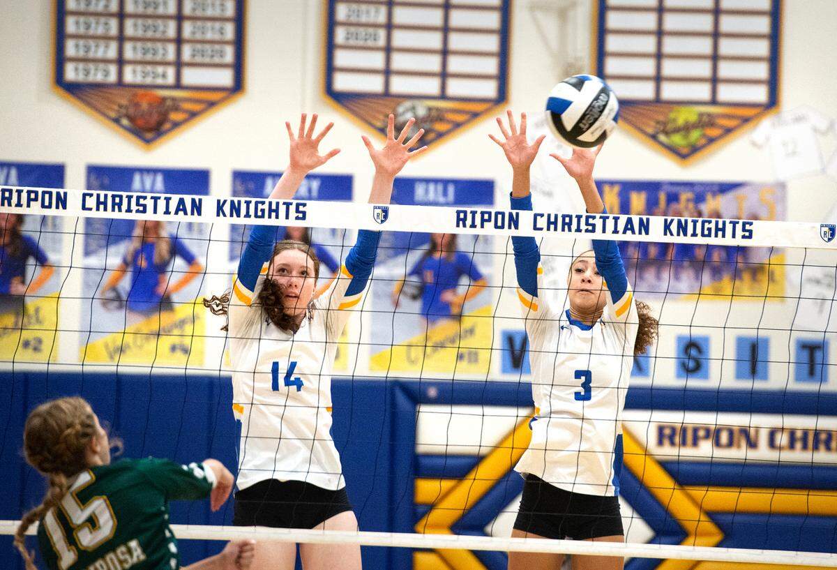 Ripon Christian’s Maddie Yonker (14) and Sydney Hoffman (3) defend at the net during the Southern League game with Mariposa County in Ripon, Calif., Thursday, Oct. 13, 2022. Ripon Christian won the match 3-0.
