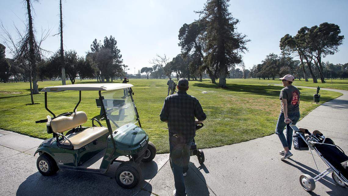 Brandon Fahlenkamp, left, and Lisa Duncan, right, walk to the 7th tee at the Modesto Municipal Golf Course in Modesto, Calif., on Saturday, Feb. 8, 2020.