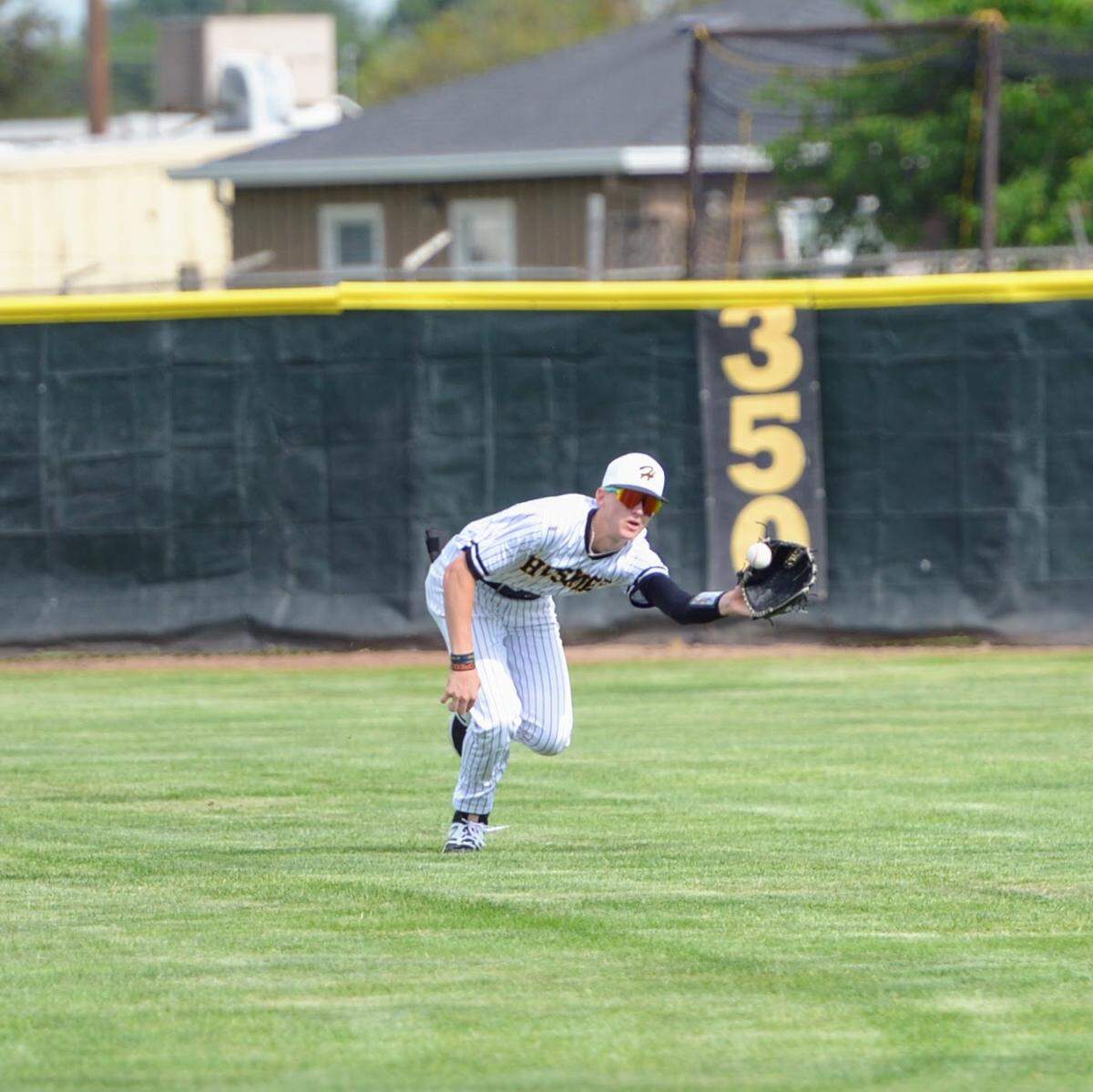 Hughson’s Bryce McDaniel makes a diving catch during a Trans Valley League game against Ripon at Ripon High School in Ripon, Calif. on April 18, 2024.