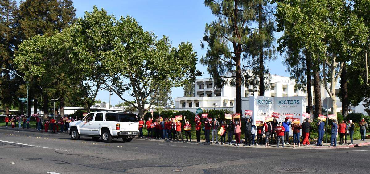 Dozens of nurses rally along Orangeburg Avenue in front of Doctors Medical Center on Wednesday, April 27, 2022, to share the message that understaffing isn’t safe for patients. A music system played a steady stream of songs, including at one point “Bad Medicine” by Bon Jovi.