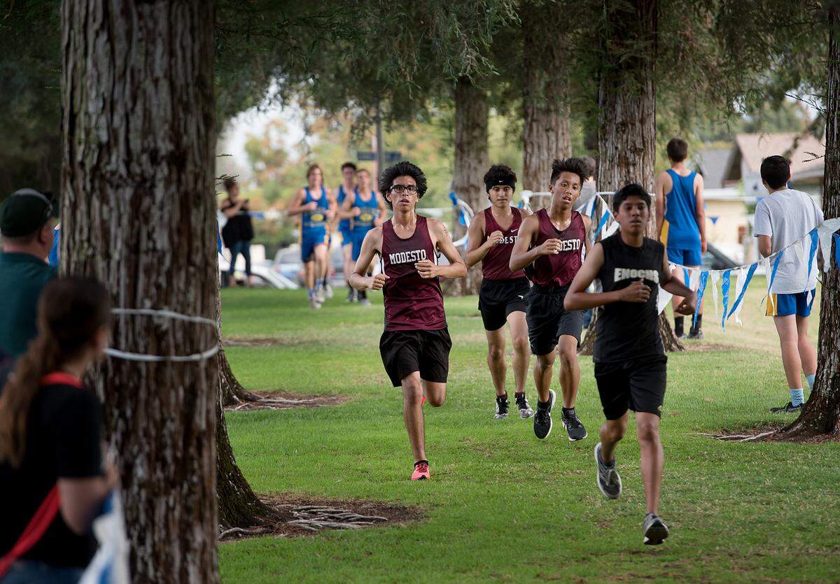 Modesto runners finish lap 2 during the CCAL meet at Donnelly Park in Turlock, Calif., on Wednesday, Oct. 3, 2018. Modesto placed second as a team behind Gregori.
