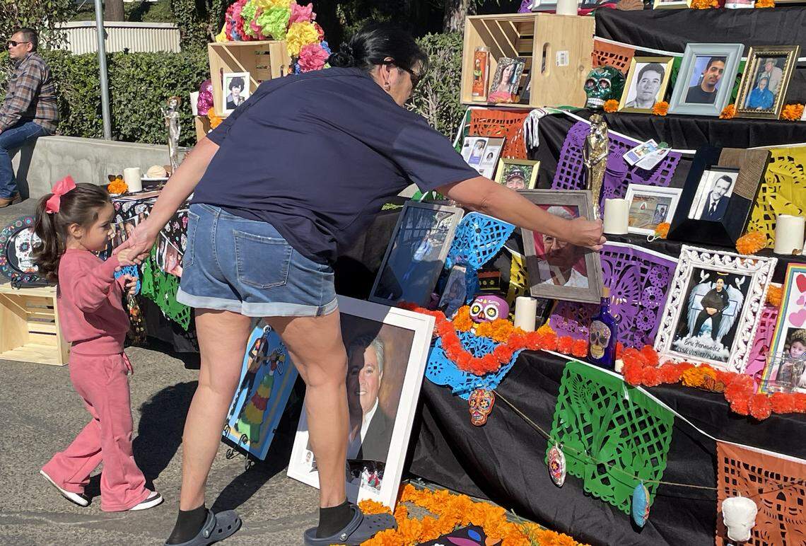 Mireyah Fragua, de 3 años, coloca la imagen de su difunto abuelo, Lucas Solis Yañez, en un altar del Día de los Muertos cerca de Hughson, Calif., el 1 de noviembre de 2025. Contó con la ayuda de su tía Cathy Bedoy-Duenas.