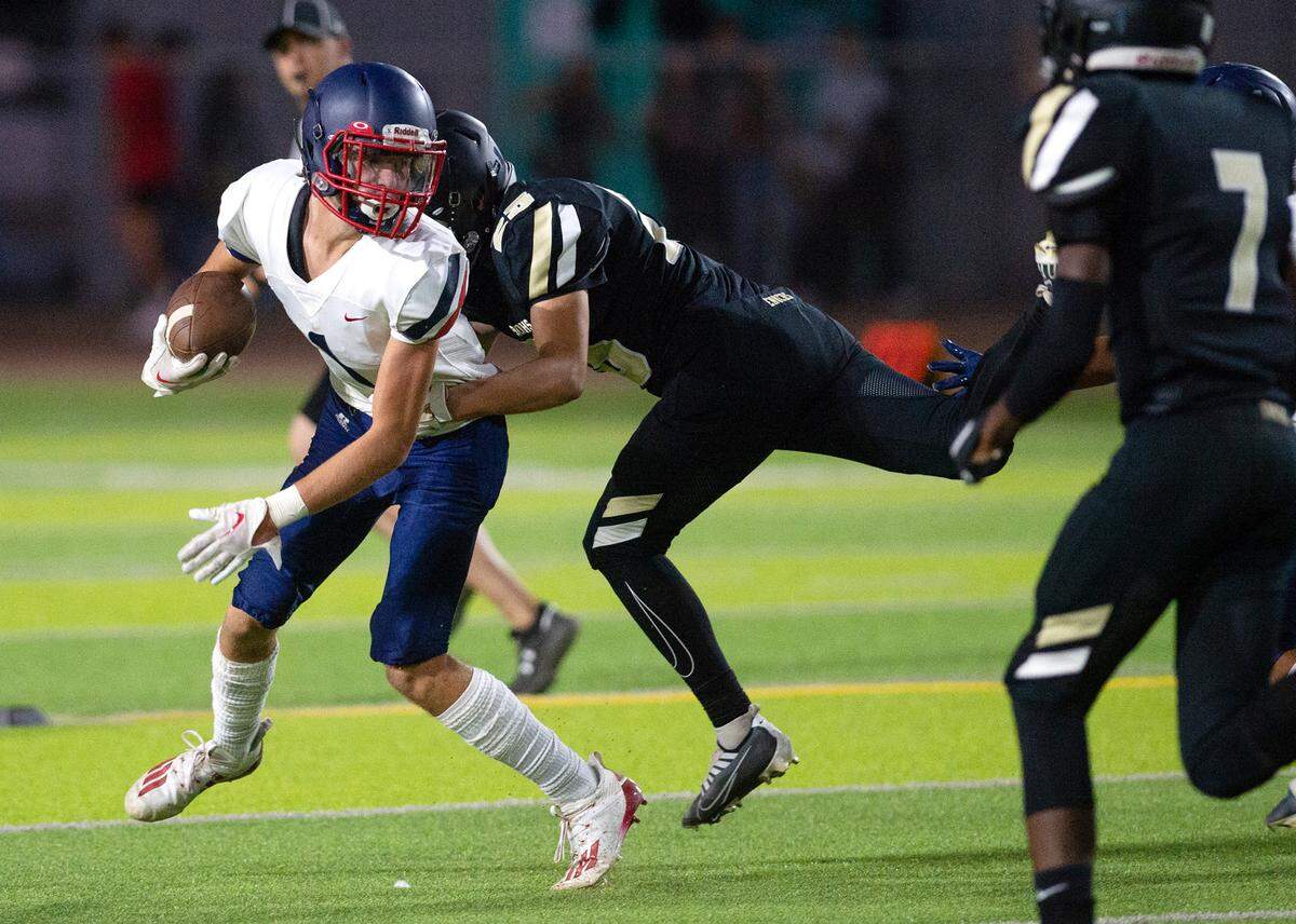 Beyer’s Blake Gross is wrapped up by an Enochs defender during the Sylvan Bowl at Downey High School in Modesto, Calif., on Friday, August 19, 2022.