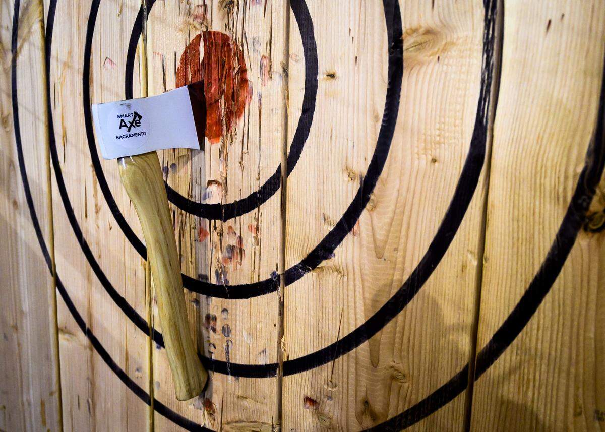 Axes thrown by Smart Axe owner and general manager Doug Link are stuck in the bullseye on Thursday, June 13, 2019. Smart Axe is a new bar in Rancho Cordova, California featuring axe throwing.