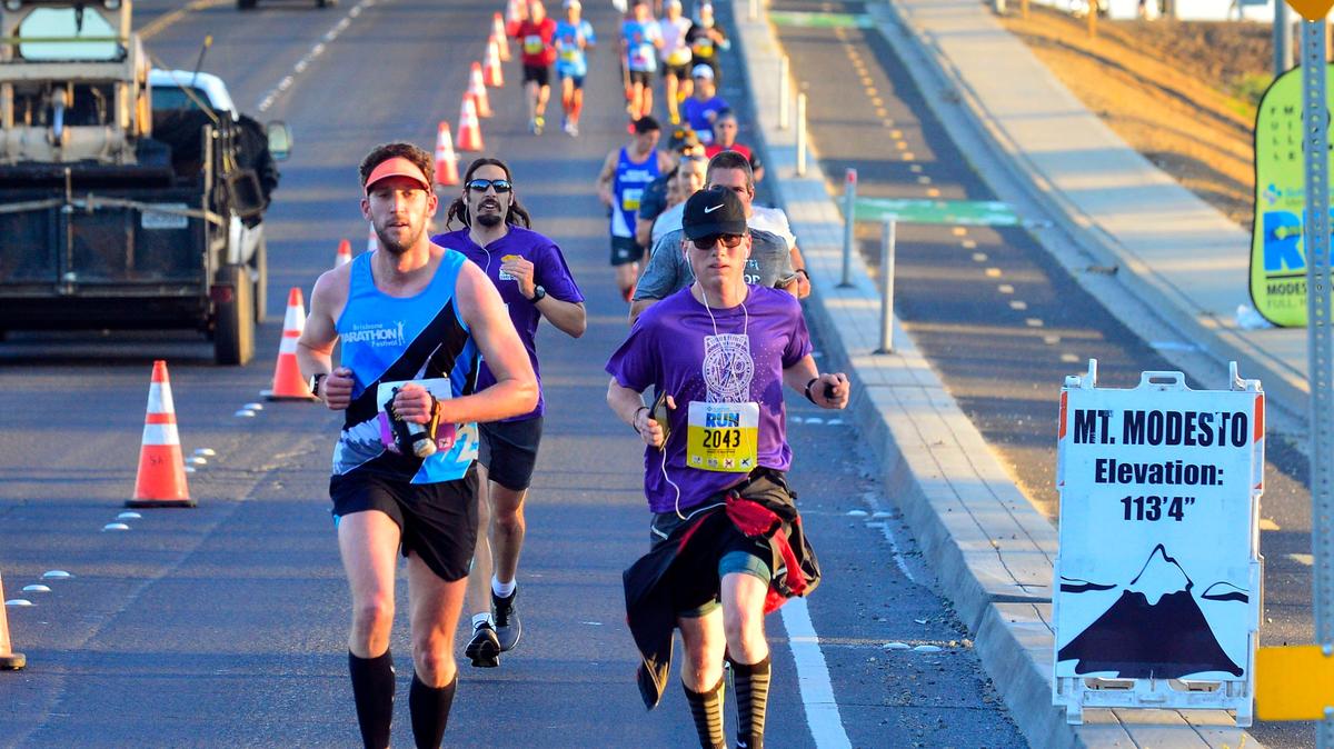 Marathon and half marathon contestants run down the Briggsmore overpass before turning on to Fire Science Ln during the Modesto Marathon on March 31 2019 in Modesto California.