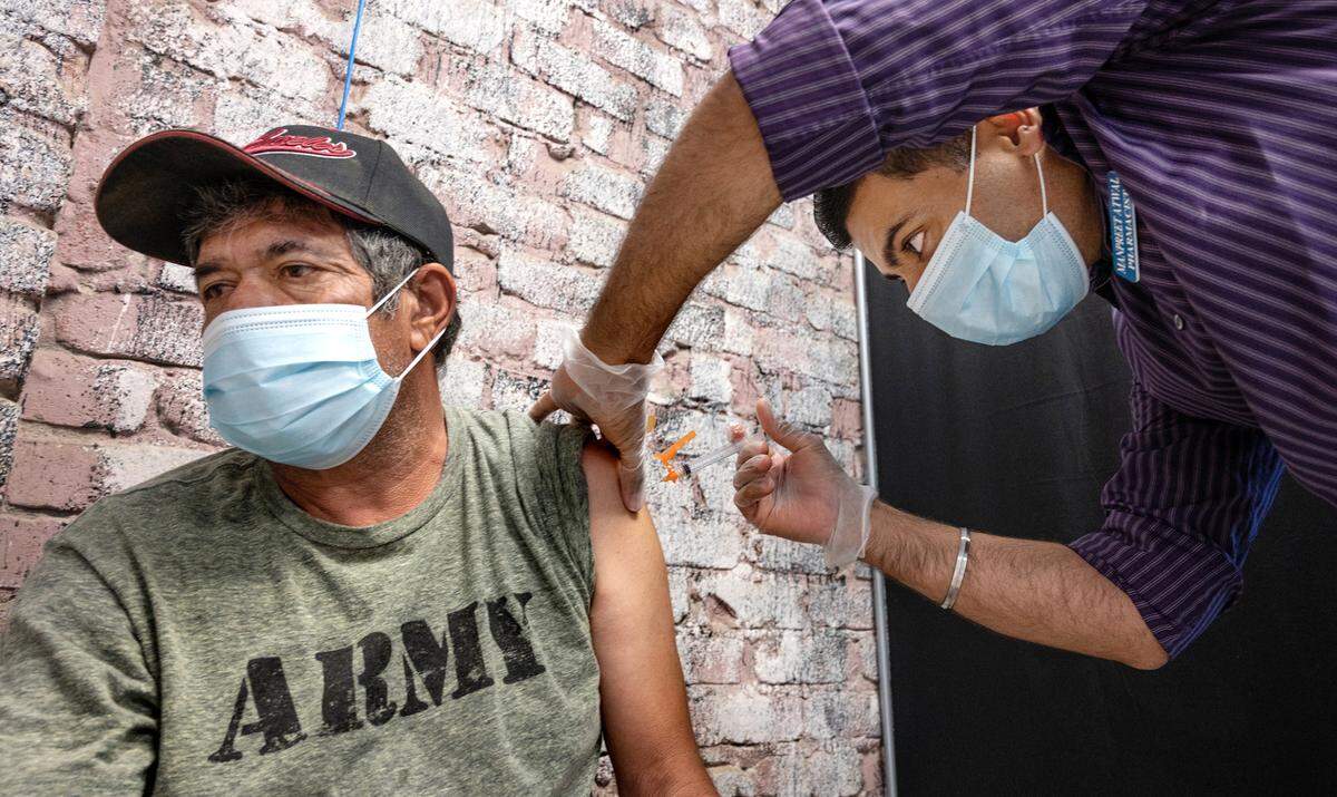 Pharmacist Manpreet Atwal gives Leobardo Arriola his second dose of the COVID-19 vaccine at Carranza Pharmacy in Hughson, Calif., on Wednesday, Sept. 15, 2021.
