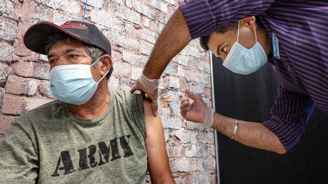 Pharmacist Manpreet Atwal gives Leobardo Arriola his second dose of the COVID-19 vaccine at Carranza Pharmacy in Hughson, Calif., on Wednesday, Sept. 15, 2021.