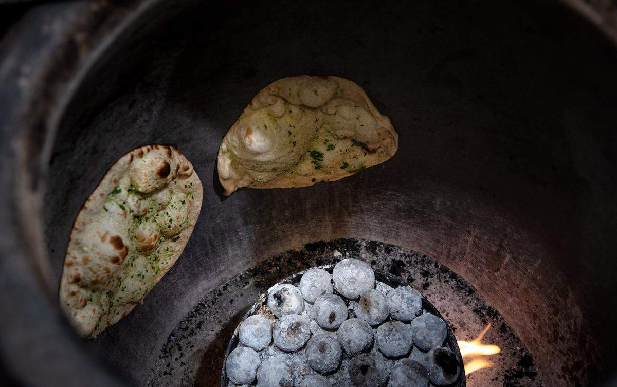 Garlic naan cooks in the oven at Tandoori Masala in Modesto, Calif., Thursday, Dec. 8, 2022.