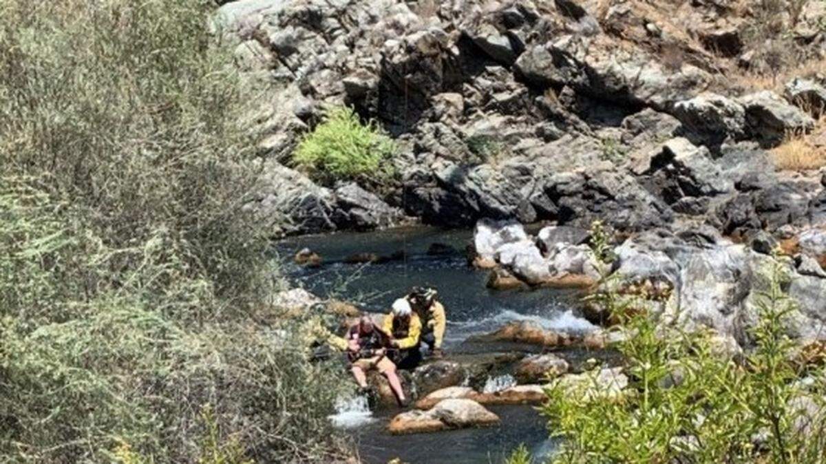 An injured hiker is harnessed to be airlifted by helicopter from rocks in the Stanislaus River at Knights Ferry on Sunday, July 26, 2020.