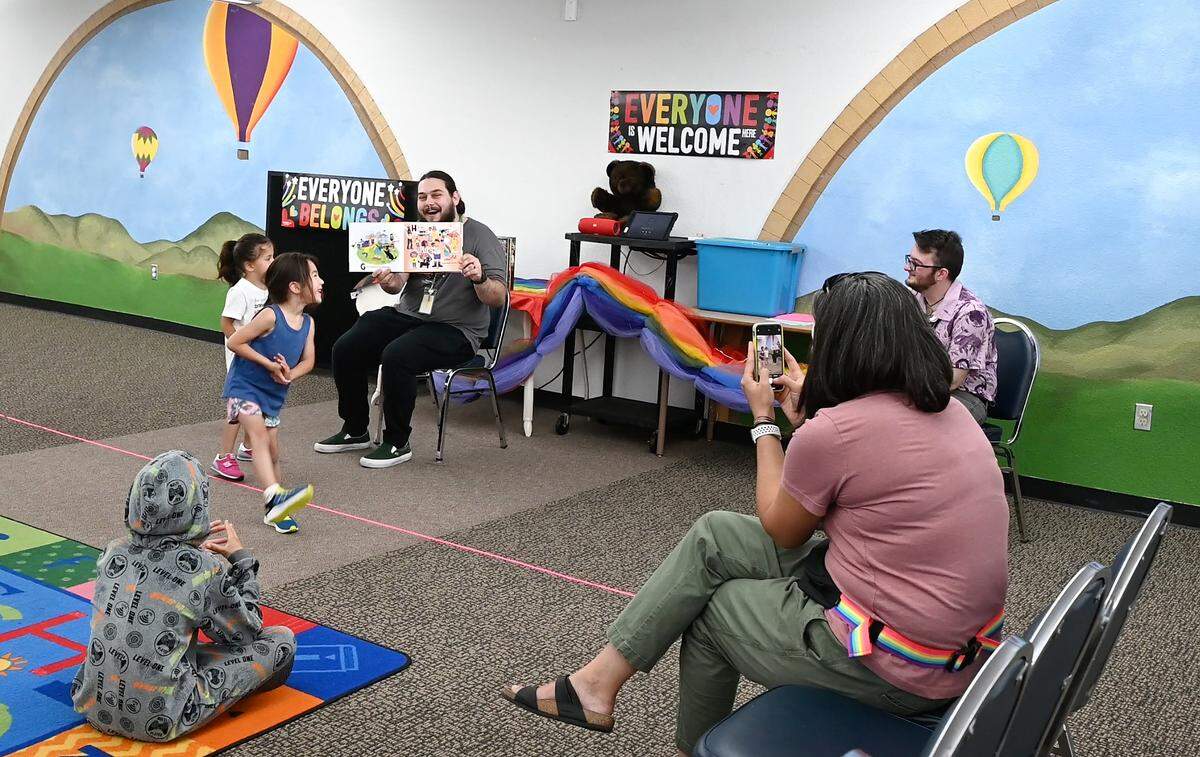 Library assistant Teddy Snyder, left, reads “Pride Puppy!” by Robin Stevenson during Rainbow Story Time at the Stanislaus County Library in Salida, Calif., Thursday, June 15, 2023.