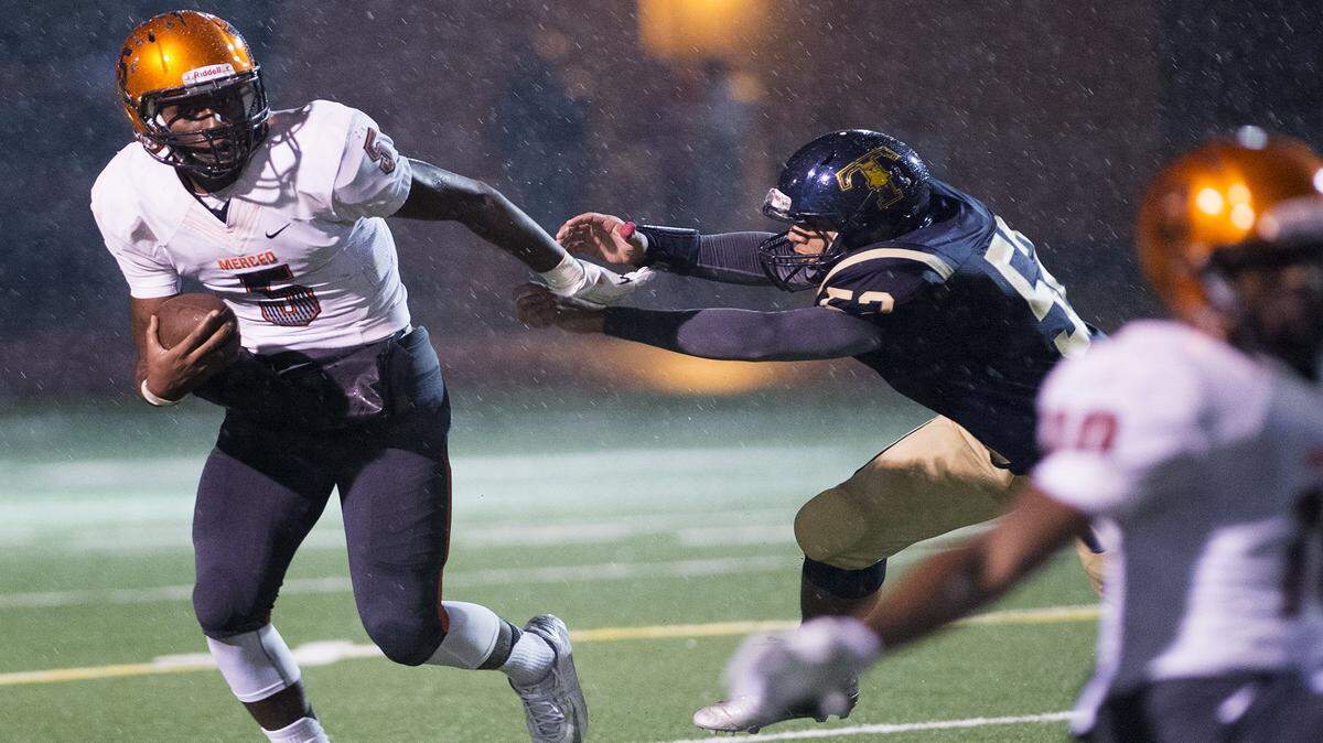 Merced quarterback Tyrone Williams shakes of Turlock's Mustafa Johnson (52) during the Central California Conference game in Turlock, Calif., on Friday, Oct. 31, 2014.
