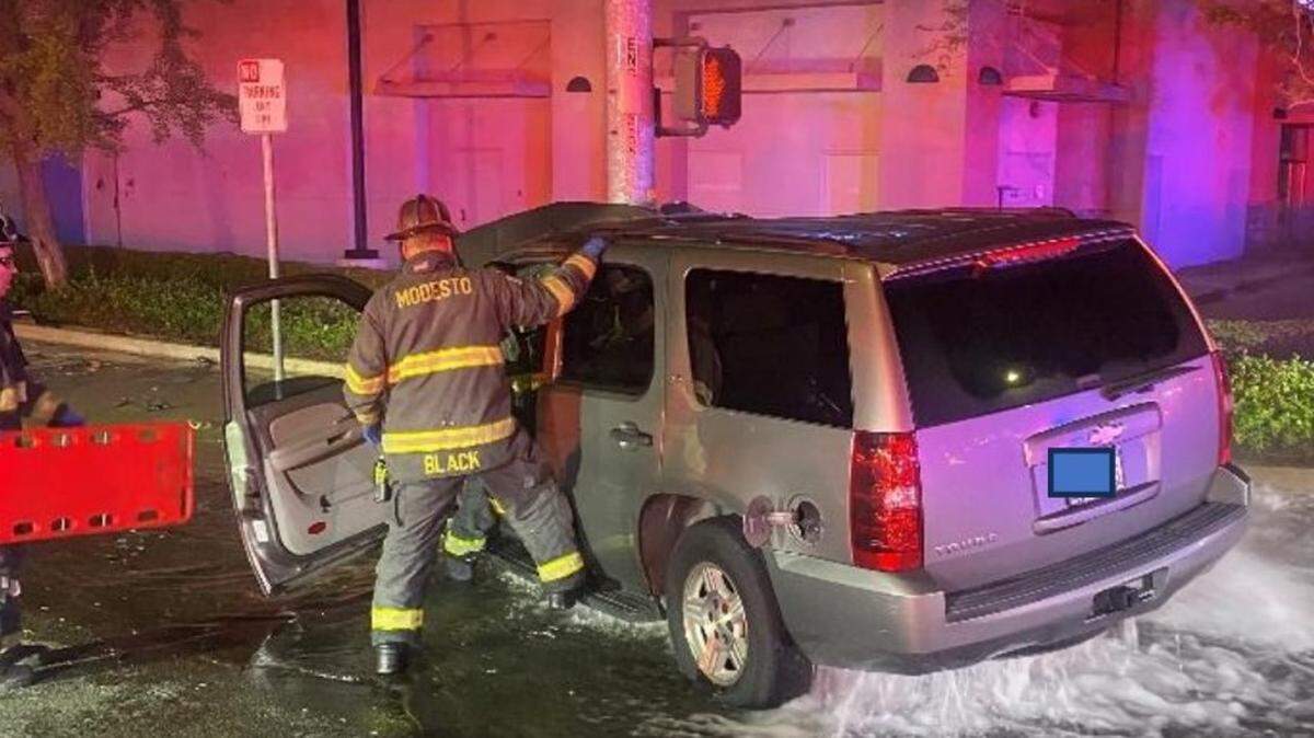 Water pours out from beneath a Chevrolet Tahoe after the driver fatally crashed into a fire hydrant and signal light pole at McHenry and Bowen avenues in Modesto on Saturday morning, April 6, 2024.