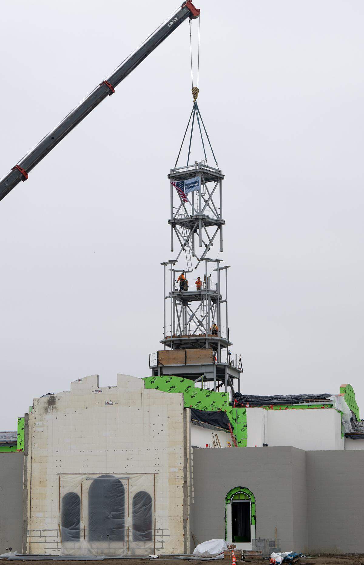 A crew places the final section of the tower at the Church of Jesus Christ of Latter-day Saints new temple on Dale Road in Modesto, Thursday, Dec. 19, 2024.