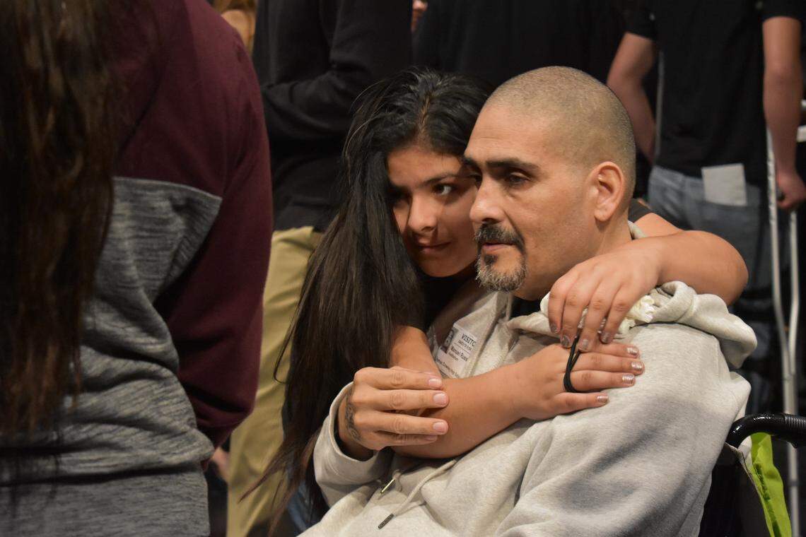 Manuel Russ is embraced by his 10-year-old daughter, Reyna, after he spoke at the Every 15 Minutes DUI awareness and prevention assembly in the Downey High School auditorium on Wednesday, April 3, 2019.