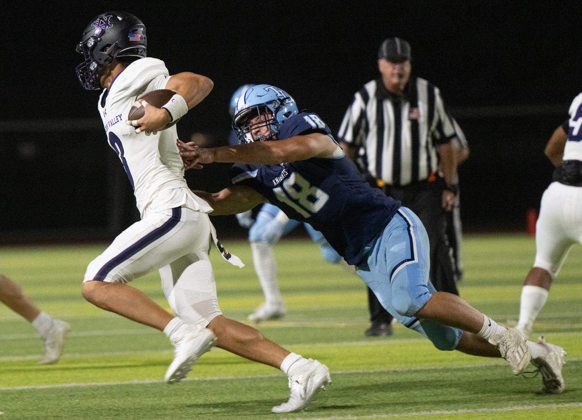 Downey’s John Hinchey pressures Amador Valley quarterback Tristan Tia during the non-league game at Downey High School in Modesto, Calif., Friday, Sept. 13, 2024.