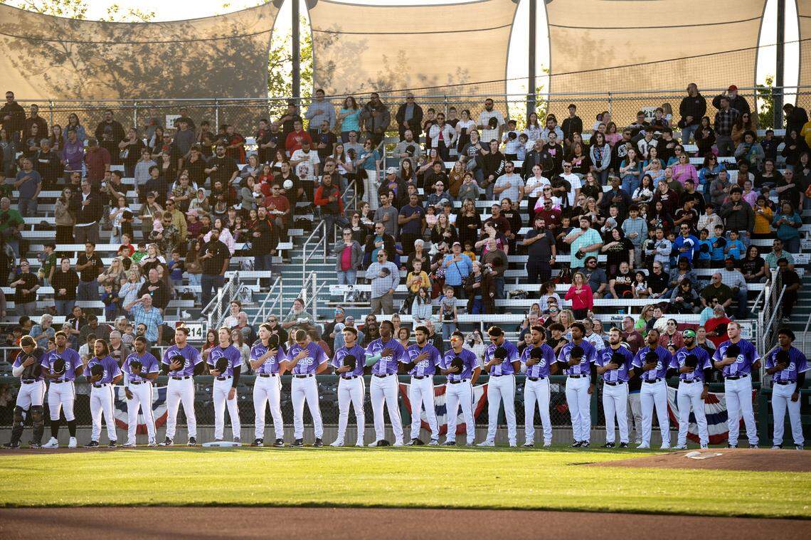 Modesto Nuts players and fans stand for the National Anthem before the start of the game with San Jose at John Thurman Field in Modesto, Friday, April 4, 2025. The Nuts wore Cancer Awareness Night jerseys during opening night.
