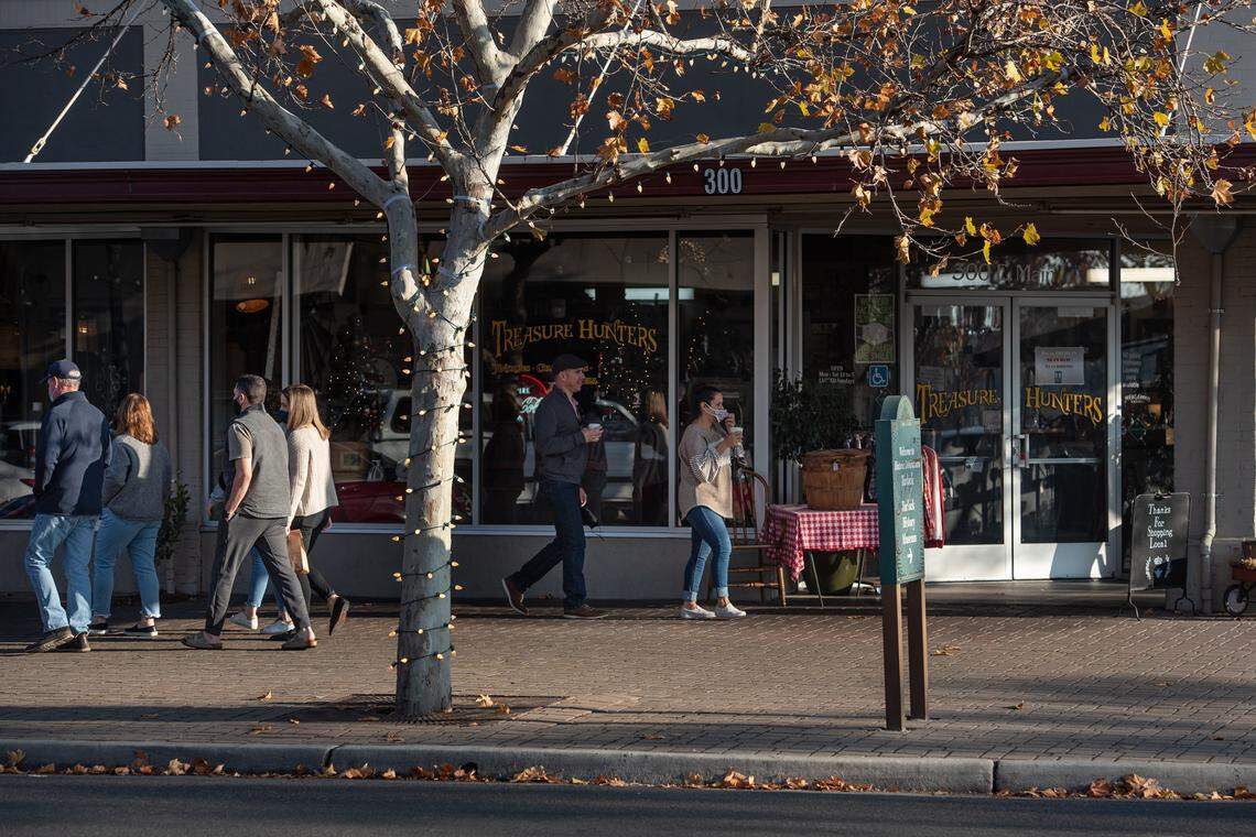 People walk along Main Street in Turlock, Calif., Saturday, Dec. 19, 2020.