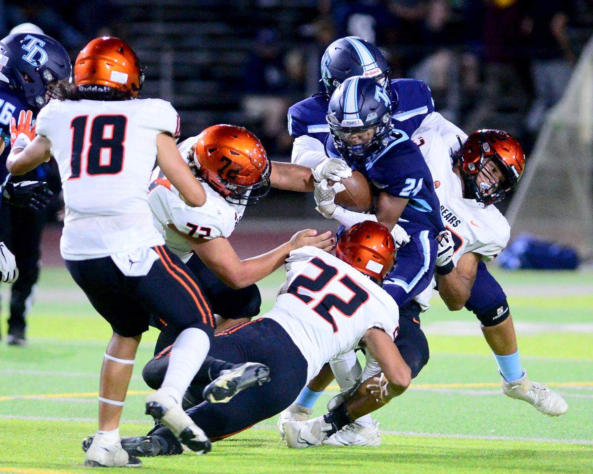 Downey running back Marcus Cruz (24) gets taken down by multiple Merced defenders during a game between Downey High School and Merced High School at Downey High School in Modesto California on September 1, 2023.