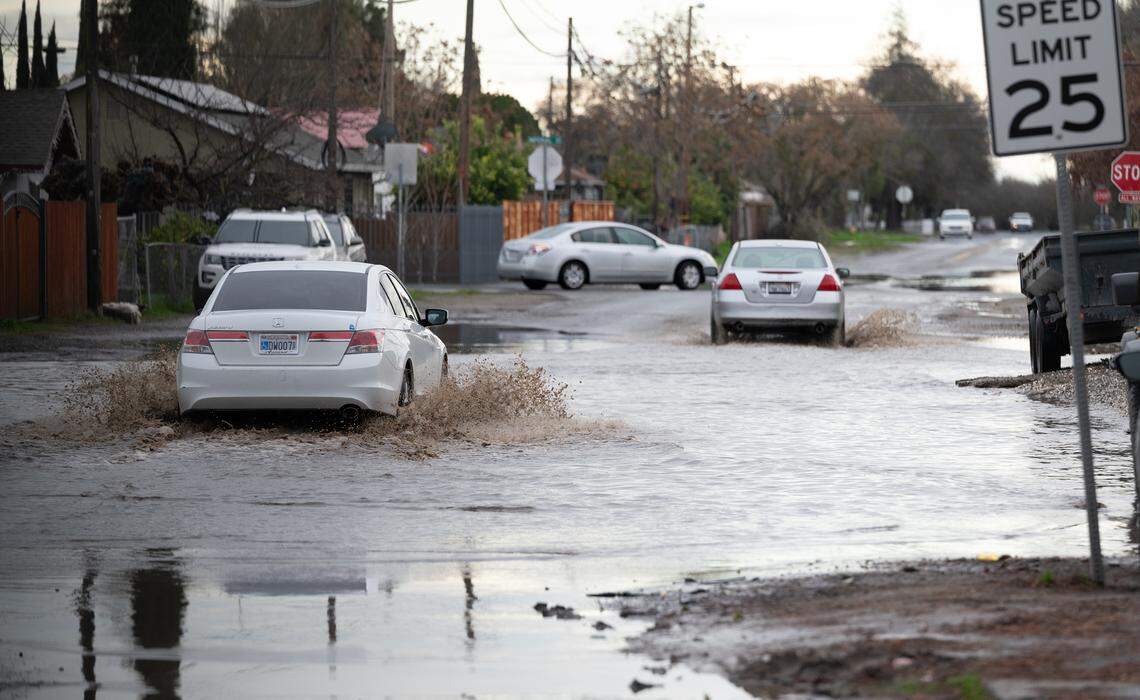 Motorists navigate a flooded section of Dallas Street in Modesto, Calif., Thursday, Jan. 5, 2023.