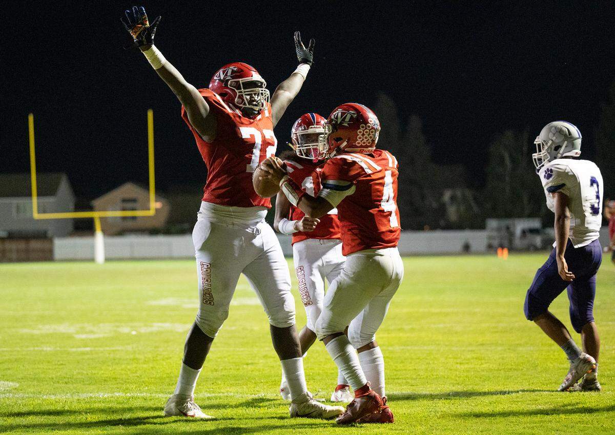Modesto Christian’s Manasse Itete, left, and Raymond Corral Jr. celebrate a two-point conversion during the non-league game with Denair at Modesto Christian High School in Salida, Calif., on Friday, August 26, 2022. Modesto Christian won the game 47-29.